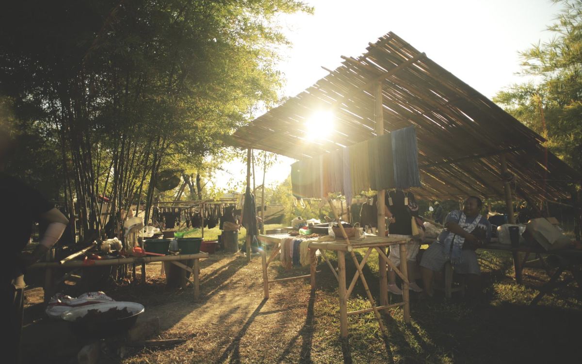 Late afternoon at the dye shed during Bamboo Family Market, dyed yarn hanging under a bamboo roof
