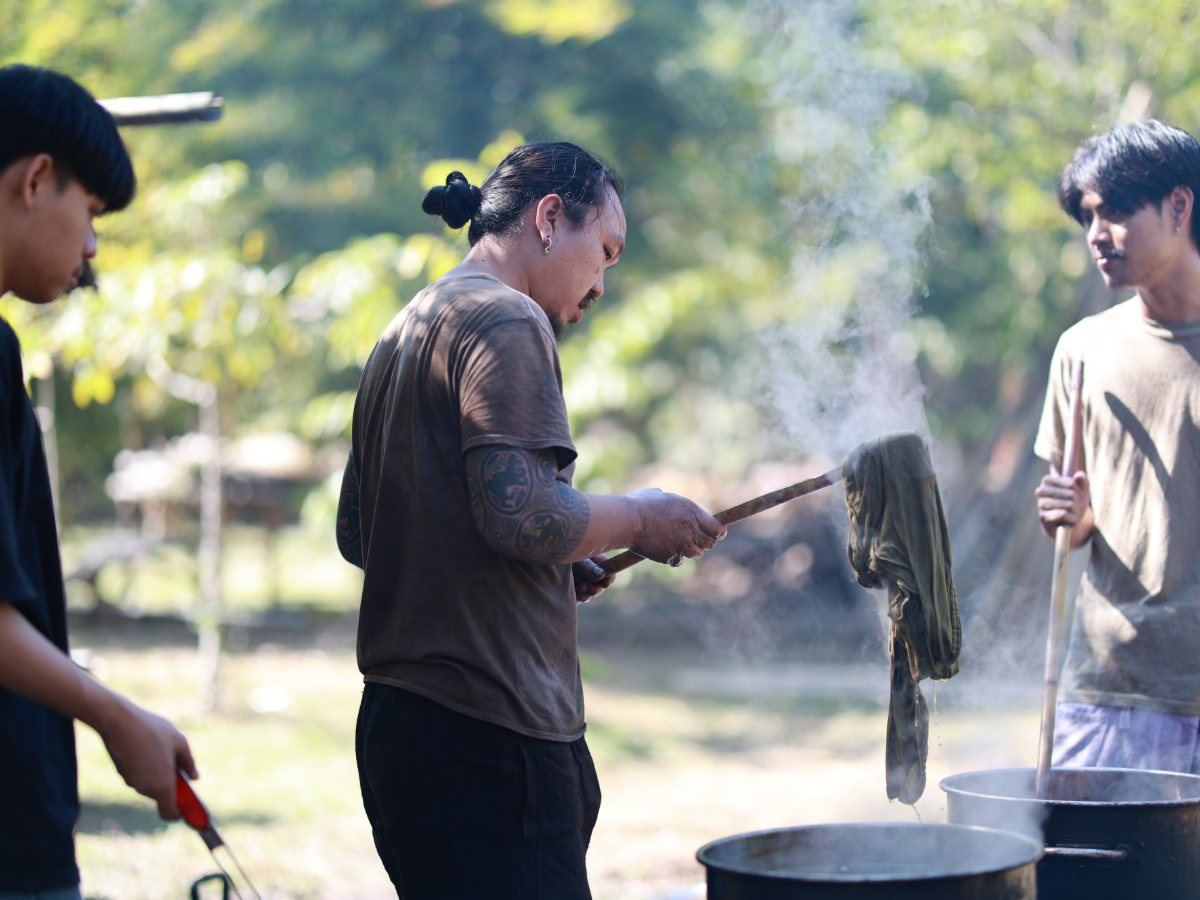 Lifting cloth from a steaming dye pot