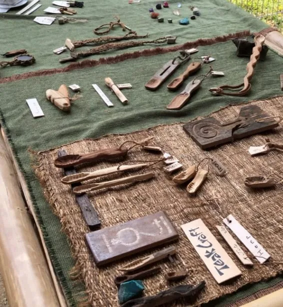 Carved wooden keychains and small craft pieces at the 84 stall