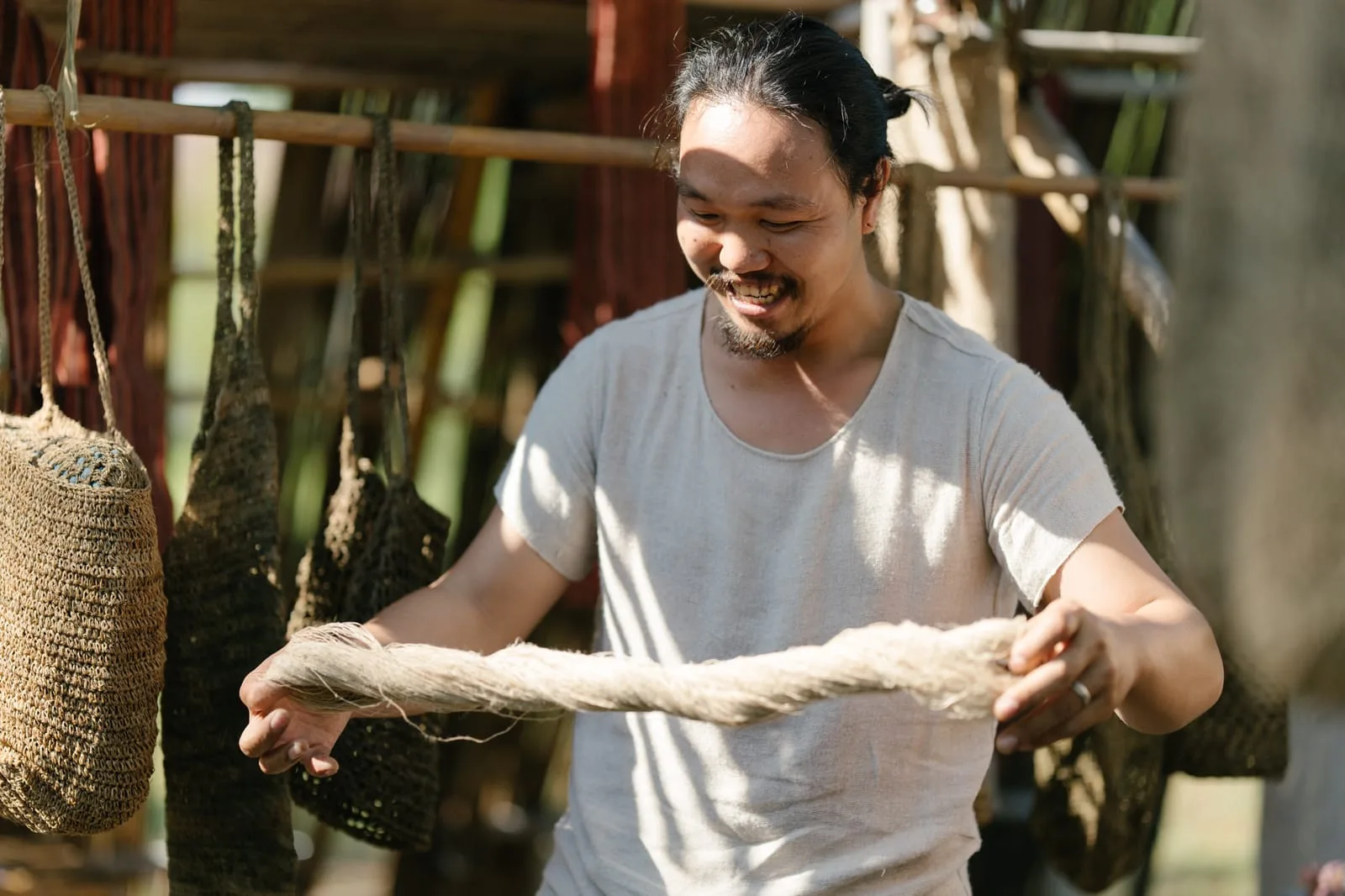 A maker holding a skein of natural-dyed hemp thread at the Karma Local stall