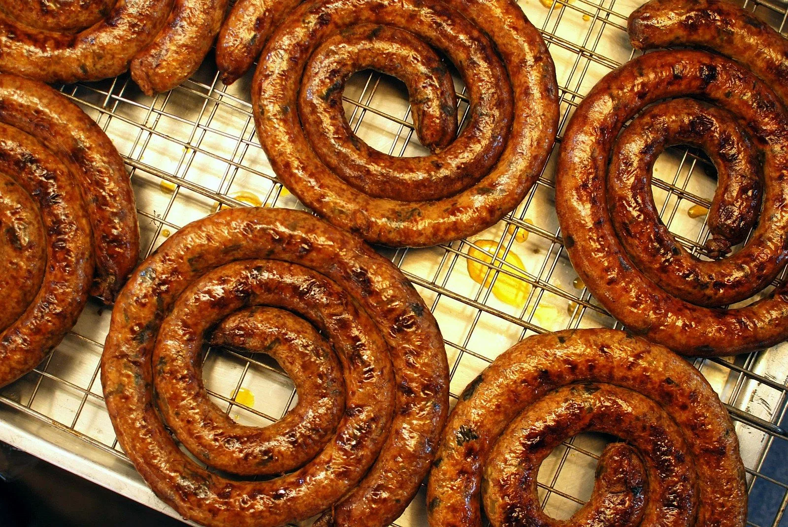 Coiled grilled Northern Thai sausages on a rack