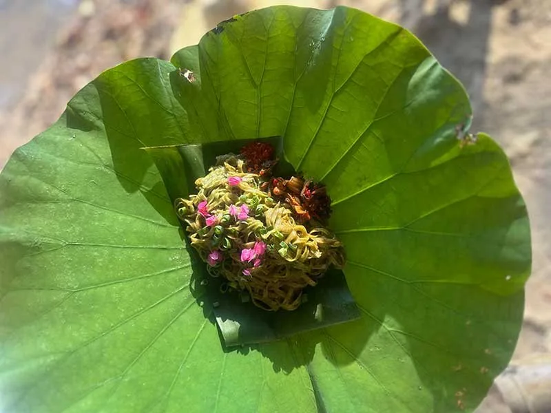Green spinach noodles served on a lotus leaf