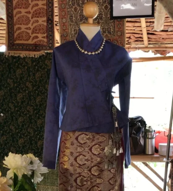 A hand-dyed jacket and woven skirt displayed on a mannequin at the Maithongkham stall